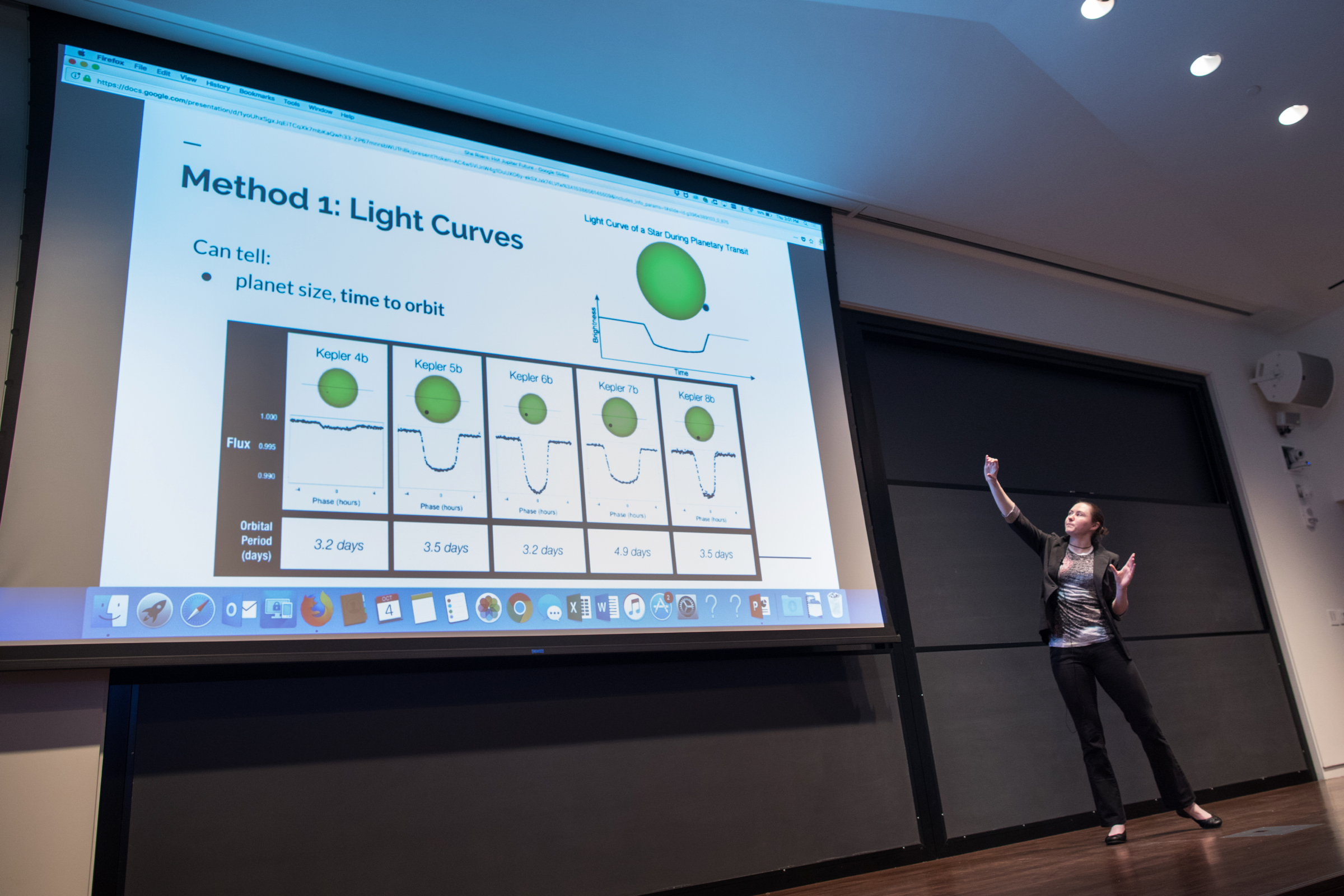 Madelyn points up at large powerpoint showing planet transits